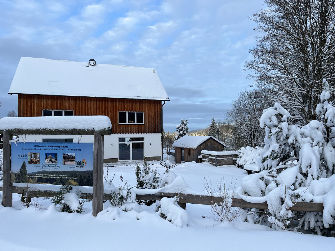 Die Berghütte Zum Kranichsee im Winter Die Berghütte Zum Kranichsee im Winter. Im Vordergrund ein Werbeschild