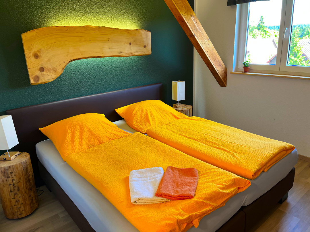 Doppelbett in einem Zimmer der Pension Talblick